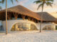 Phối cảnh tổng thể Sand Dune Retreat của H2 Architects với mái lá uốn cong và khung tre bên bãi biển